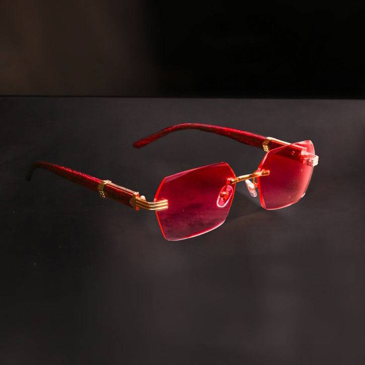 Lunettes de soleil rouges Elite Eyewear avec monture dorée, accessoire de mode audacieux pour un look estival unique.