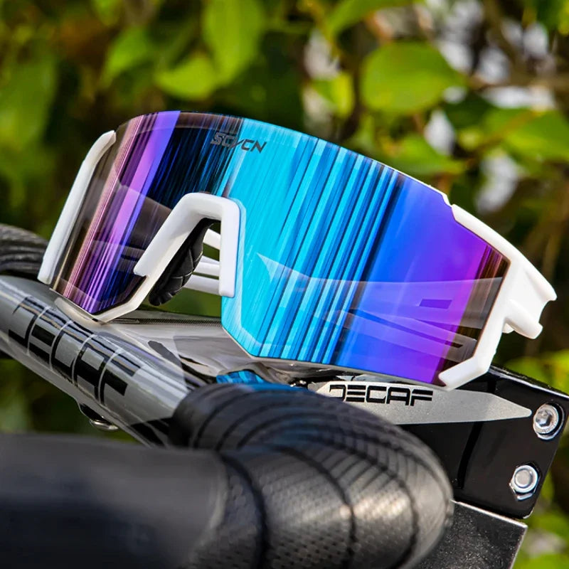 Lunettes Cyclisme SCVCN - Protection UV400 avec monture blanche et verres miroir bleus, posées sur un guidon de vélo, idéales pour le sport outdoor.