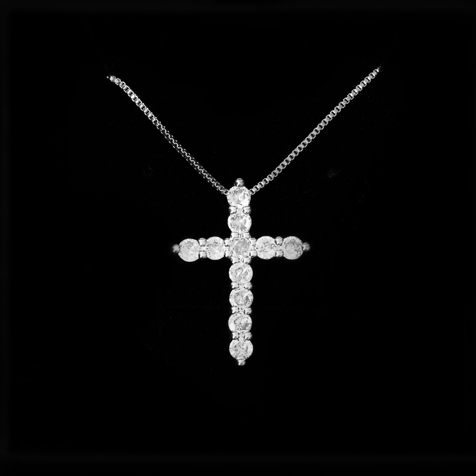 Pendentif croix en acier inoxydable argenté avec cristaux scintillants, suspendu à une chaîne fine pour un style raffiné.