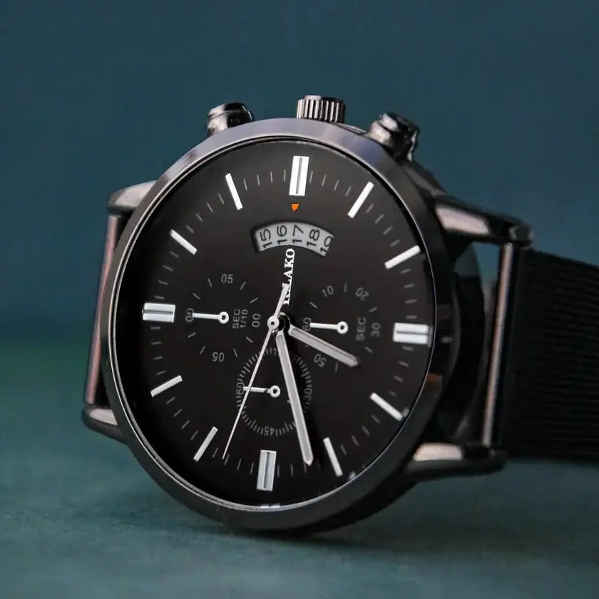 Montre Infinity noire avec cadran noir et bracelet en acier inoxydable. Un design sobre et moderne, idéal pour un style élégant et polyvalent.