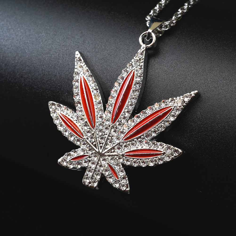 Pendentif feuille en acier inoxydable avec incrustations de topaze et détails rouges. Chaîne de 50 cm, design élégant et résistant à l'oxydation.